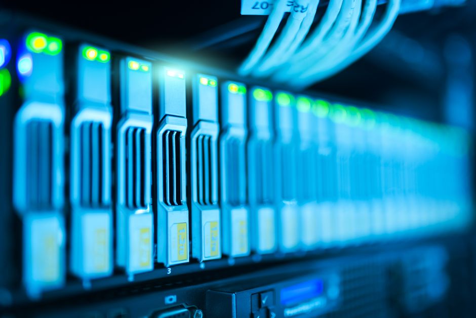 Imagem detalhada de um rack de servidores com luzes brilhantes em um data center moderno.