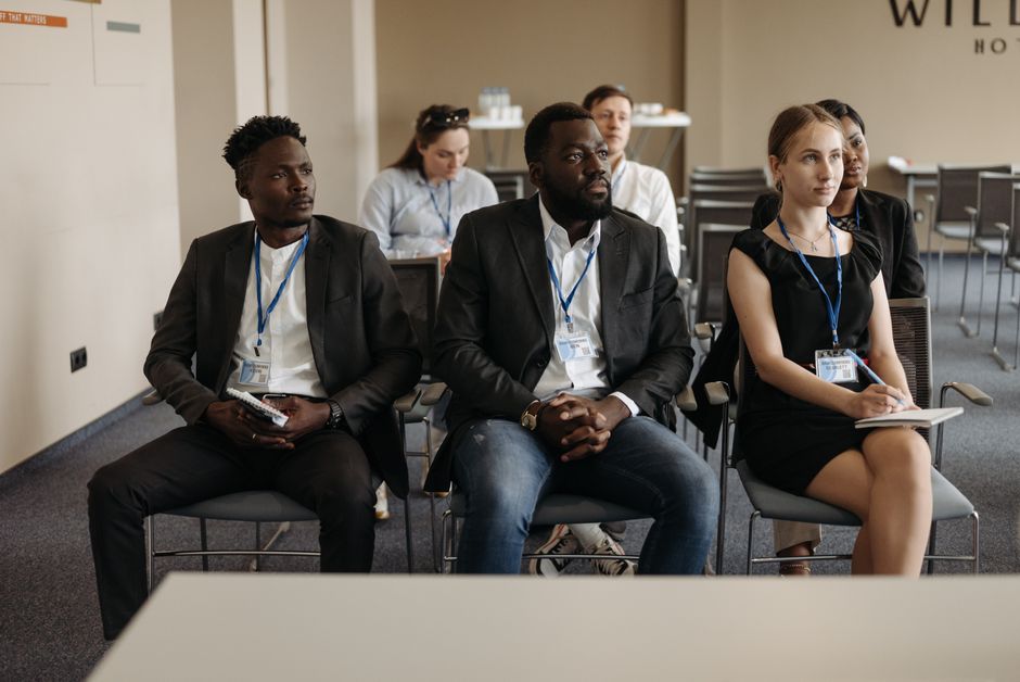 Um grupo diversificado de profissionais ouvindo atentamente durante um seminário de negócios em uma sala de conferências.