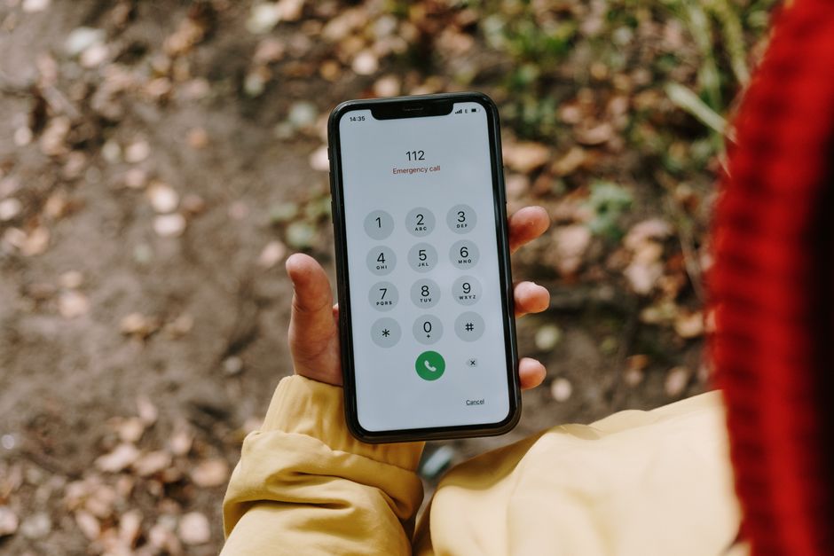 Close-up de um smartphone exibindo o número de emergência 112 ao ar livre.