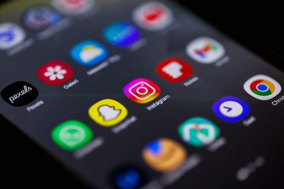 Visão aproximada da tela inicial do smartphone com aplicativos populares como Instagram, Snapchat e Chrome.