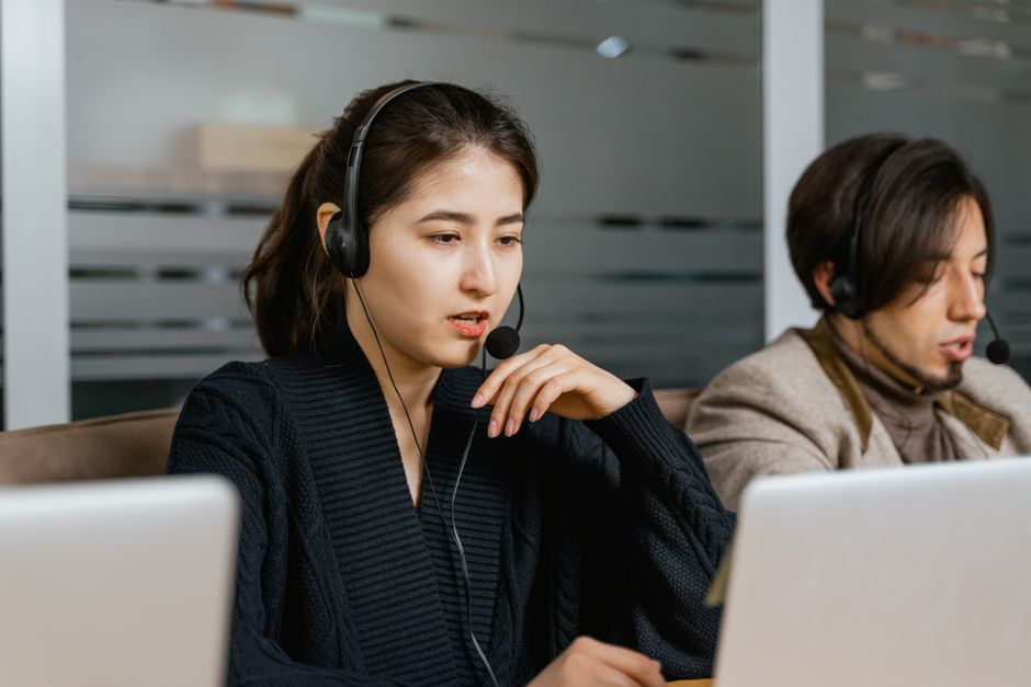 Dois agentes de call center fornecendo suporte ao cliente em um ambiente de escritório moderno.