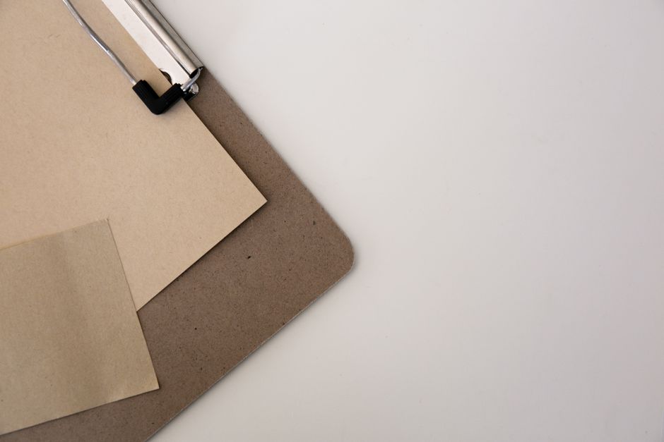 Vista superior de uma prancha com folhas de papelão sobre um fundo branco.