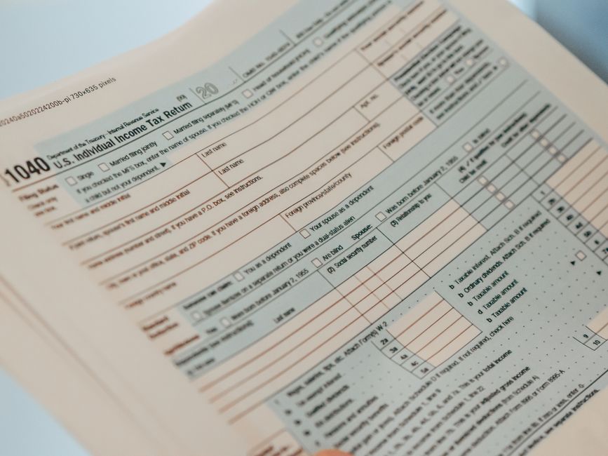 Imagem de close-up detalhada de um formulário U.S. 1040 de Declaração de Imposto de Renda Individual, ideal para conteúdo relacionado a finanças.